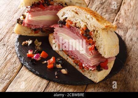 Sandwich Cajun Muffaletta avec olives à la viande et fromage gros plan sur un tableau d'ardoise sur la table. Horizontale Banque D'Images