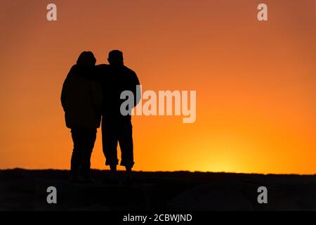 Senior couple bénéficie d'une jetée de coucher du soleil. Banque D'Images