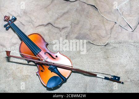 le magnifique violon repose sur un vieux morceau de matière. Banque D'Images