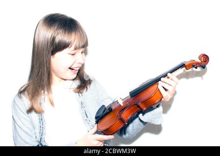 l'enfant tient le violon et sourit. Banque D'Images