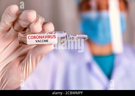 Covid-19, vaccin contre le coronavirus. Les mains de gros plan du scientifique montrent le vaccin Covid-19 dans un flacon en verre. Mains du médecin porter un gant en latex blanc tenant Covid-1 Banque D'Images