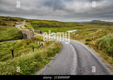 Une route rurale qui se déforme dans les collines De Connemara Banque D'Images