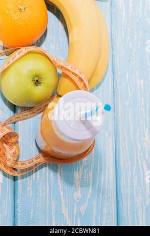 Smoothie banane et orange sur fond en bois bleu clair. Banque D'Images