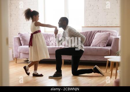 Un père africain attentionné enseignant le bal danse sa fille préadolescente Banque D'Images