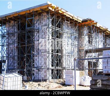 échafaudage autour d'une maison en cours de construction à partir de blocs Banque D'Images