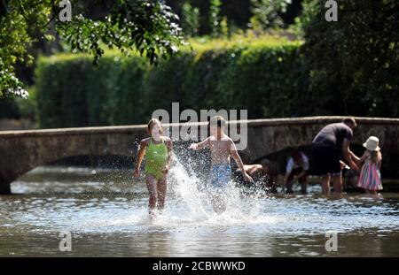 La vague de chaleur se poursuit dans les Cotswolds où les températures ont grimpé à 33 degrés et la foule a rempli les greens d'herbe à la Côté de la rivière Windrush i Banque D'Images