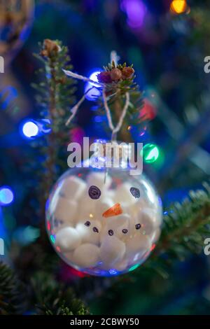 Décoration bonhomme de neige faite à la main sur l'arbre de Noël avec lumières colorées arrière-plan Banque D'Images