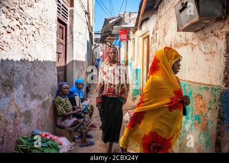 Femmes swahili avec des voiles colorés dans les stries de la Ville de Lamu au Kenya Banque D'Images