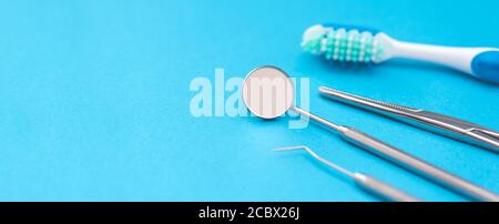 Outils professionnels pour dentistes sur fond bleu. Concept de soins dentaires. Banque D'Images