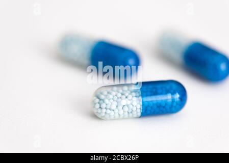 Capsule bleue, pilules sur fond blanc. Concept de soins de santé, médecine, pharmacie Banque D'Images