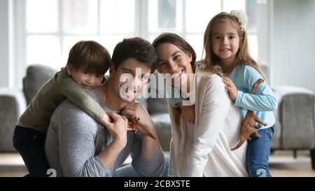 Jeunes parents heureux jouant avec les enfants à l'intérieur. Banque D'Images