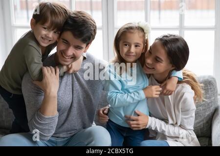 Heureux adorables petits enfants câliner affectueux parents amoureux. Banque D'Images