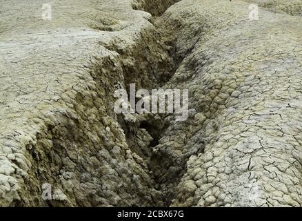 Canal d'eau non ondulé dans une texture de sol sec. Les volcans Mud est une réserve géologique et botanique à Paclele mari près de Buzau, Roumanie. Petit volume Banque D'Images