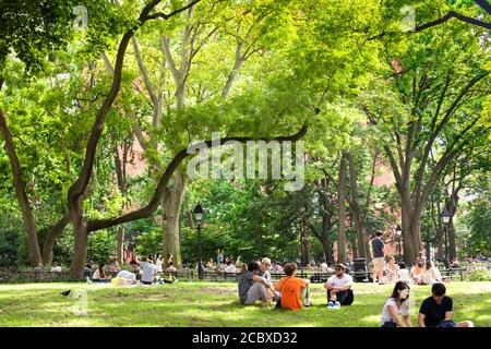 New York City - 15 août 2020 : les gens se détendent sur une scène de l'après-midi d'été au Washington Square Park à Manhattan. Banque D'Images