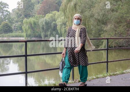 Une femme musulmane portant un foulard se promène le long du lac à Kissena Park, à Flushing, dans la ville de New York Banque D'Images