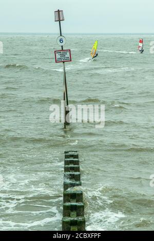 Deux véliplanchistes vus juste à côté de la gryone no.6 sur la plage à Hunstanton. Banque D'Images