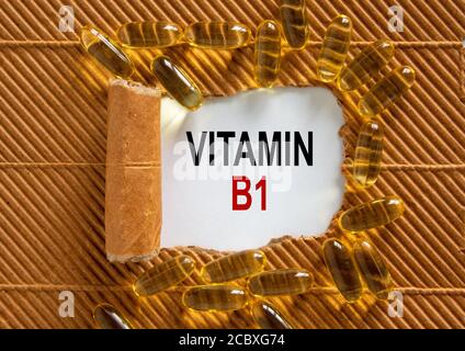 Le texte « vitamine B1 » apparaît derrière un papier marron déchiré. Pilules jaunes. Concept. Magnifique arrière-plan. Banque D'Images