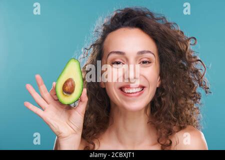 Jeune femme belle et joyeuse avec luxueux cheveux ondulés regarder à vous Banque D'Images