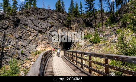 Faire du vélo au-dessus des ponts en bois du chemin de fer abandonné de Kettle Valley dans le canyon Myra, près de Kelowna, en Colombie-Britannique, au Canada Banque D'Images