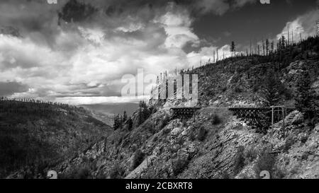 Photo en noir et blanc d'une série de ponts en bois du chemin de fer abandonné de Kettle Valley dans le canyon Myra, près de Kelowna (Colombie-Britannique), Cana Banque D'Images