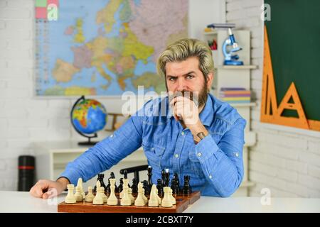 Concept de stratégie. Professeur d'école. Faites votre propre pensée de manière indépendante. Leçon d'échecs. Jeu de société. Homme intelligent jouant aux échecs. Figures sur le plateau d'échecs. Passe-temps intellectuel. Réfléchir à l'étape suivante. Banque D'Images