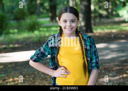 Fille scout mignon braides porter des vêtements à carreaux nature fond, concept de camp d'été. Banque D'Images