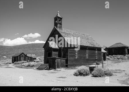 Vue en noir et blanc sur l'église de la ville fantôme sauvage de l'ouest et d'autres bâtiments du parc historique de l'État de Bodie en Californie. Banque D'Images