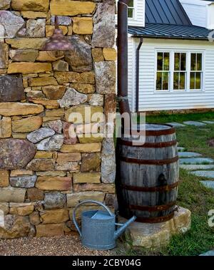 Barrel de pluie le long de Stone garage Banque D'Images