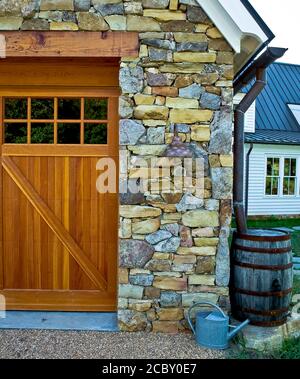 Barrel de pluie le long de Stone garage Banque D'Images