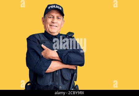 Homme haut de page portant un uniforme de police heureux visage souriant avec des bras croisés regardant la caméra. Personne positive. Banque D'Images