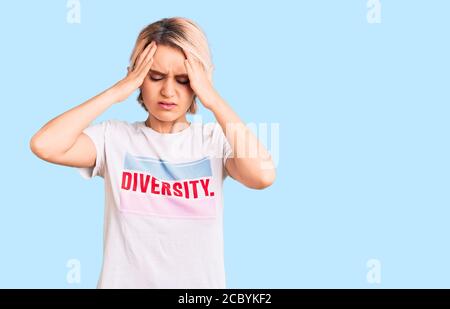 Jeune belle femme blonde portant t shirt avec message de mot de diversité souffrant de maux de tête désespérés et stressés parce que la douleur et la migraine. han Banque D'Images
