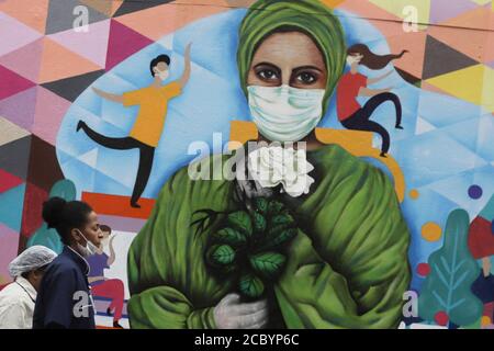 Sao Paulo, Brésil. 16 août 2020. Les médecins passent par un graffiti peint sur un mur pour rendre hommage aux travailleurs de la santé dans le contexte de l'épidémie de COVID-19 dans un hôpital de Sao Paulo, au Brésil, le 16 août 2020. Credit: Rahel Patrasso/Xinhua/Alamy Live News Banque D'Images