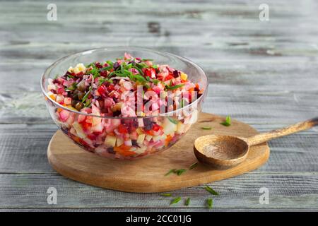 Bol de salade de betteraves vinaigrettes traditionnelle, planche en bois, cuillère Banque D'Images