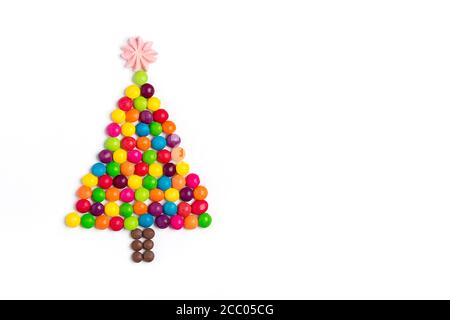 Arbre de Noël en mélange de bonbons au chocolat coloré, étoile en meringue isolée sur fond blanc carte de vacances bonne année, fête, minimale Banque D'Images