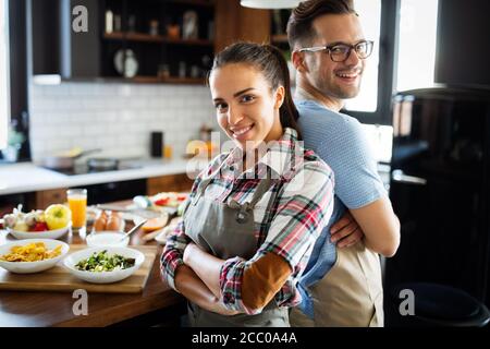 Des gens heureux, couple de cuisiner la nourriture ensemble dans leur cuisine loft à la maison Banque D'Images
