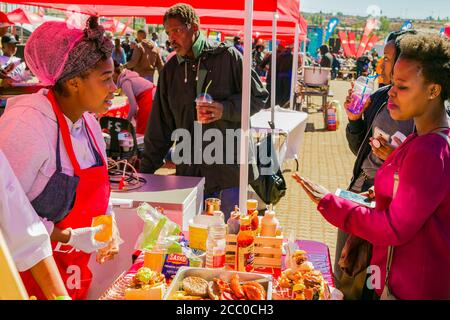 Soweto, Afrique du Sud - 8 septembre 2018 : divers vendeurs africains cuisinant et servant divers plats de rue à base de pain au festival en plein air Banque D'Images