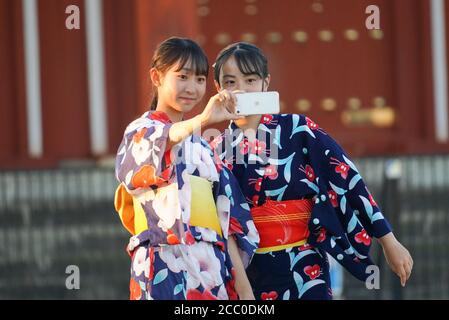 Nara, Japon. 16 août 2020. Les filles portant des robes de yukata prenant des selfies pendant le festival Nara. Le festival a été transformé en un événement artistique de projection numérique dans le contexte d'une pandémie de coronavirus. Nara était l'ancienne capitale du Japon dans les 700 et le festival est célèbre pour sa marche dans laquelle les gens portent des costumes aristocratiques lumineux. Crédit : SOPA Images Limited/Alamy Live News Banque D'Images