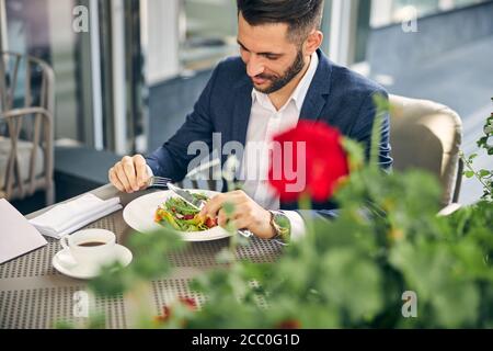 Un homme à barbe heureux qui apprécie son délicieux dîner Banque D'Images