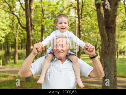 Grand-père portant petit-fils sur les épaules. Homme âgé et petit-fils Banque D'Images