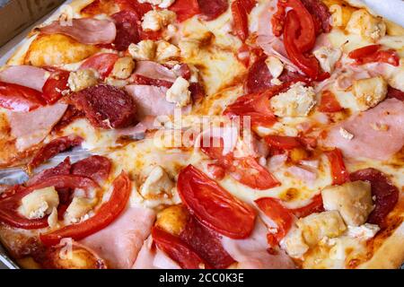 Pizza avec viande et tomates en gros plan Banque D'Images