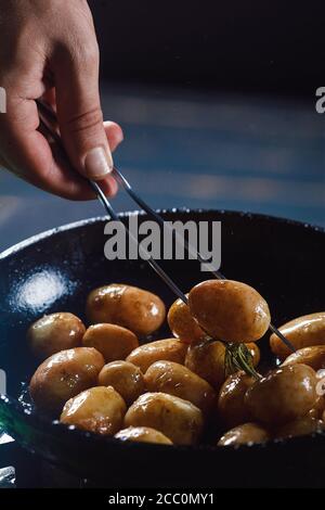 Jeunes pommes de terre bouillies à l'huile et à l'ail rôti, dans un plat en bois. Banque D'Images