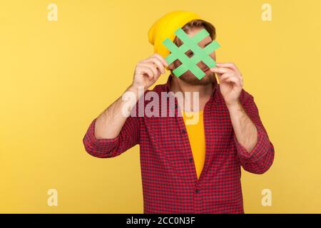 Hashtag, tendances Internet. Hipster Guy dans bonnet beanie, chemise à carreaux regardant par le grand signe de hash, curieux regardant le message viral dans le réseau social. Banque D'Images