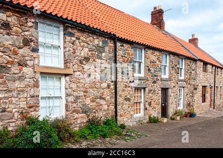 Une rangée mitoyenne de vieilles maisons traditionnelles construites à partir de la nature roches colorées et remplies de mortier pour boucher les espaces et compenser les différentes tailles Banque D'Images