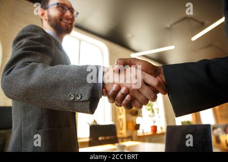 Gros plan d'hommes d'affaires qui se branchent dans une salle de conférence, qui font un marché, un accord réussi ou une coopération. Concept de finance et d'affaires, contrats, partenariat, communauté et travail d'équipe. Banque D'Images