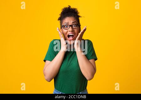 Surprise afro femme dans les spécifications criant au studio Banque D'Images