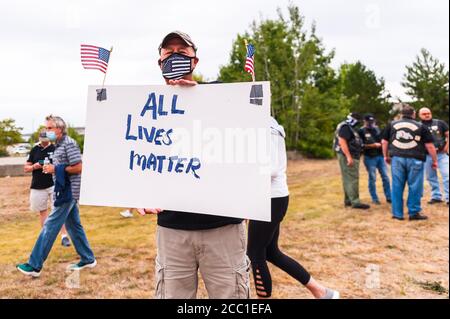 Homme portant un masque COVID avec drapeau bleu fin et tenant un panneau toutes les vies sont importantes pour un rassemblement pour montrer son soutien à la police locale. Banque D'Images