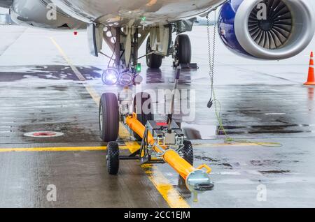 Porte-REMORQUEUR pour avion, remorque avant train d'atterrissage tracteur d'aérodrome de refoulement avec avion sur la piste de l'aéroport Banque D'Images