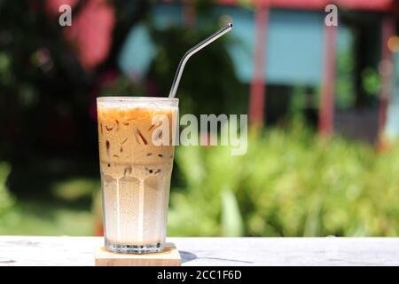 Café macchiato au caramel glacé avec paille en acier inoxydable pour boisson. Concept pour réduire la pollution plastique et soutenir les produits écologiques. Banque D'Images