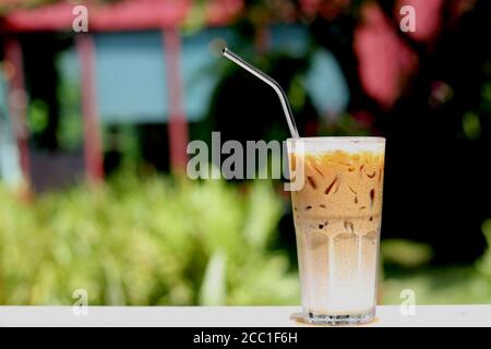 Café macchiato au caramel glacé avec paille en acier inoxydable pour boisson. Concept pour réduire la pollution plastique et soutenir les produits écologiques. Banque D'Images