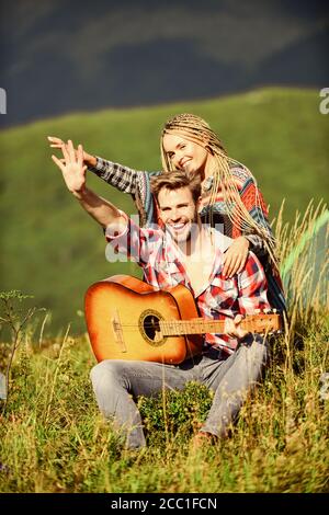 L'air frais et pur des sentiments. Petit ami et petite amie avec la guitare. Randonnées romantiques. Promenade romantique. Chanson romantique. L'amour qui les inspire. Beau couple romantique happy smiling faces fond nature. Banque D'Images